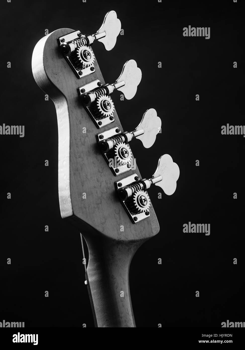 Schwarz / weiß Foto von einer Bassgitarre Kopfplatte über schwarzen Hintergrund. Stockfoto