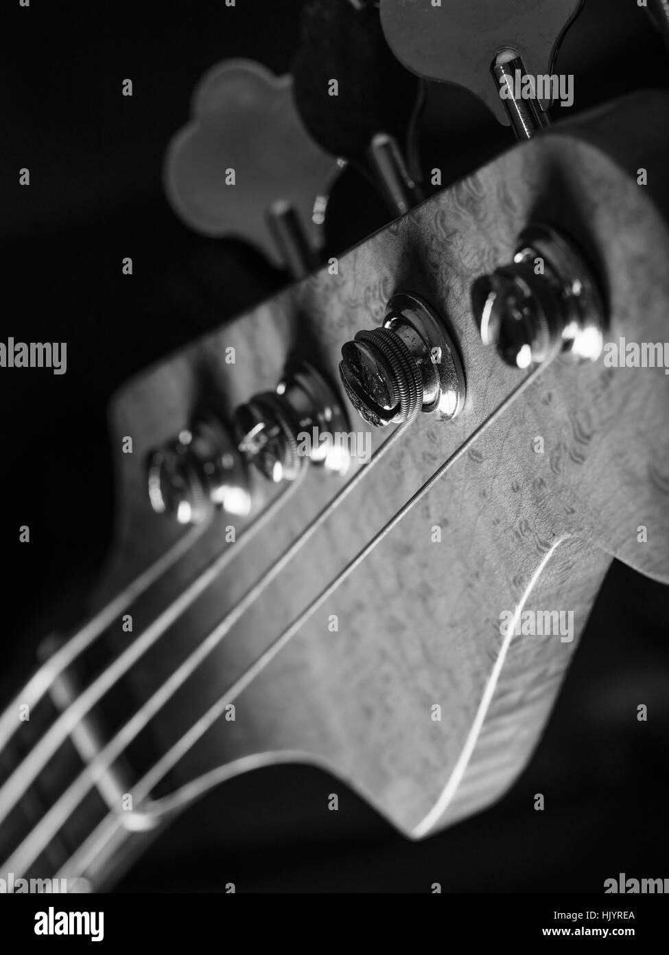 Schwarz / weiß Foto von einer Bassgitarre Kopfplatte über schwarzen Hintergrund. Stockfoto