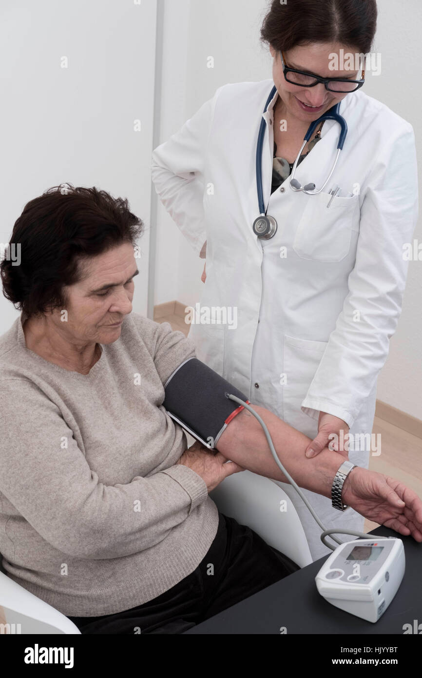 Arzt überprüft Blutdruck senior Patientin Stockfoto