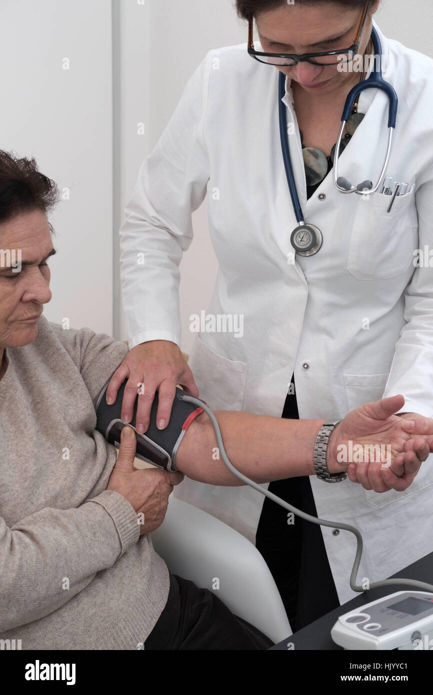 Arzt überprüft Blutdruck senior Patientin Stockfoto