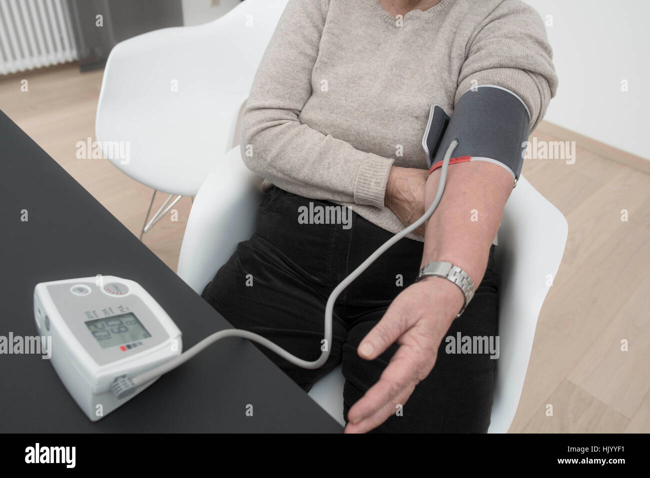 Ältere Frau prüft ihre eigenen Blutdruck Stockfoto