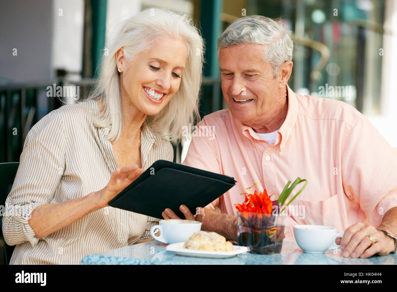 Älteres Paar mit Tablet-PC am Café im freien Stockfoto
