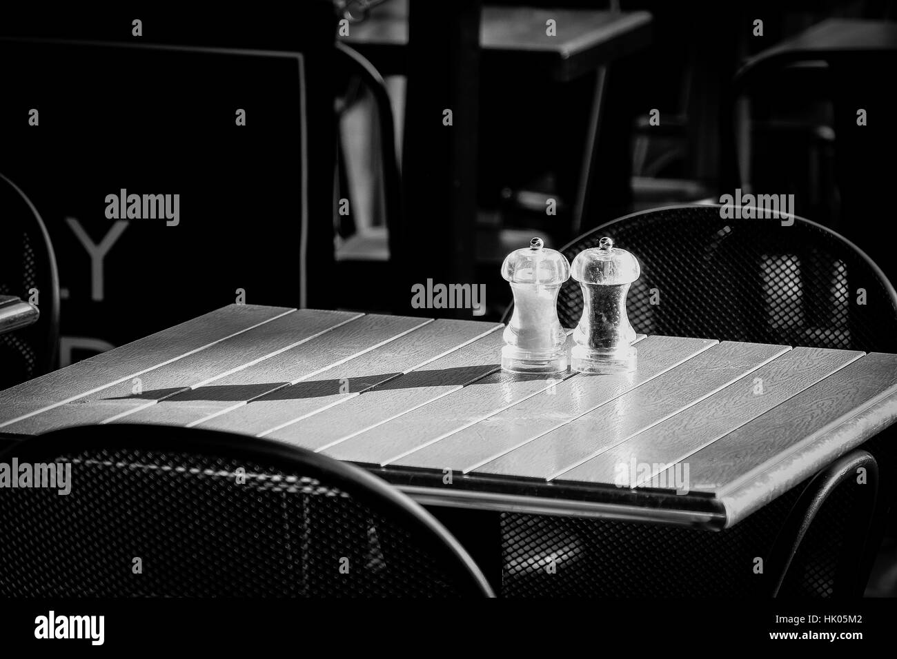 Die Sonne scheint Einstellung schafft lange Schatten auf ein Restaurant im freien Tisch Stockfoto
