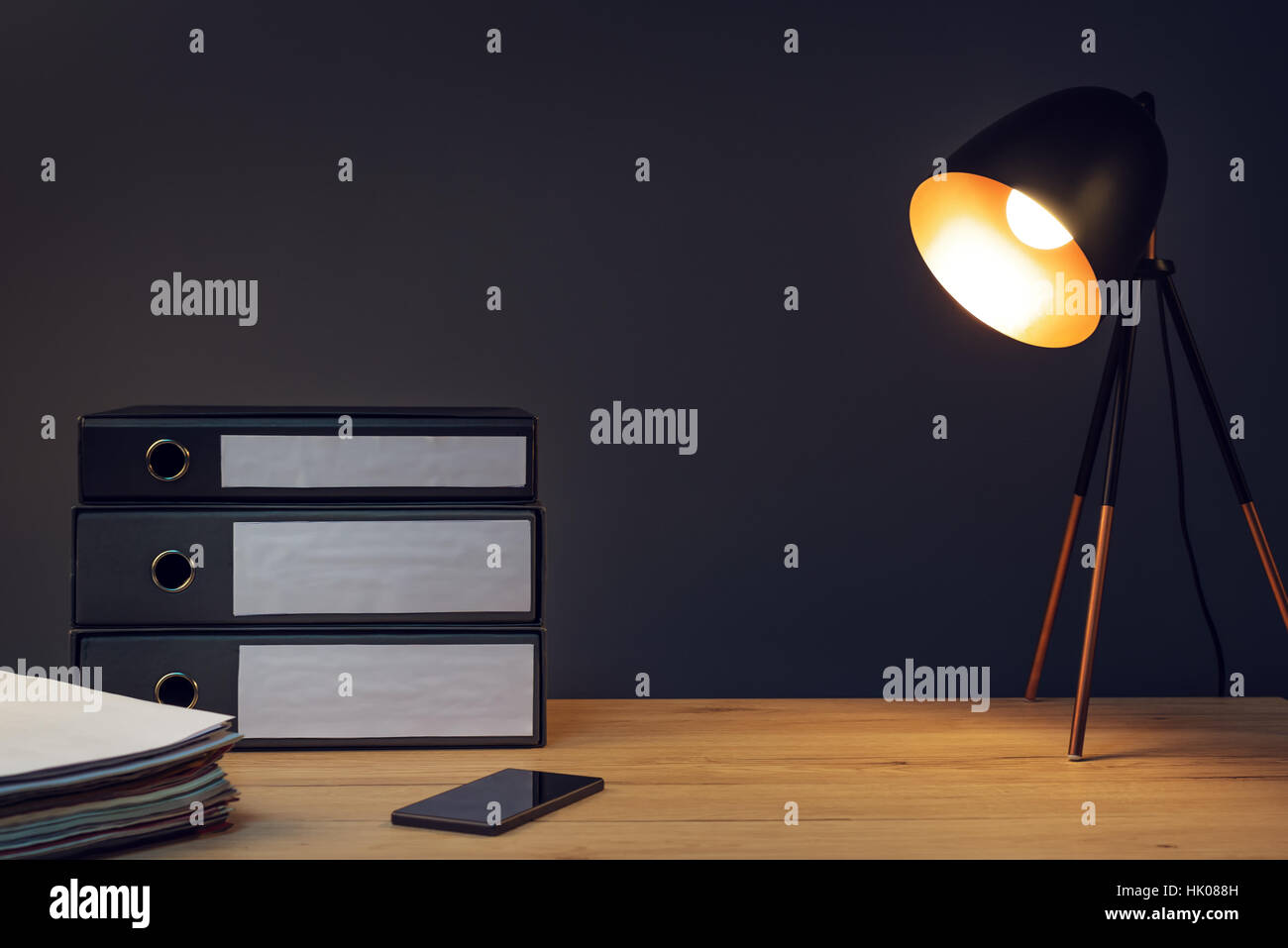 Schreibtisch mit Lampe, Handy und Papierkram stack Stockfoto