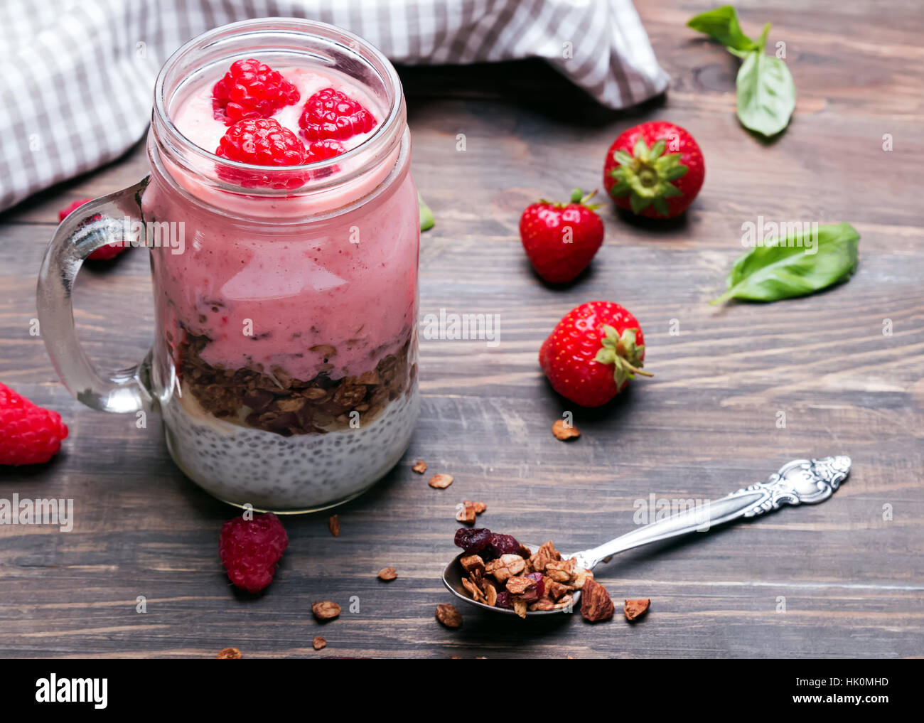 Chia Pudding mit Müsli und Erdbeeren in einem Glas auf dem Holztisch. Gesundes Frühstück. Stockfoto