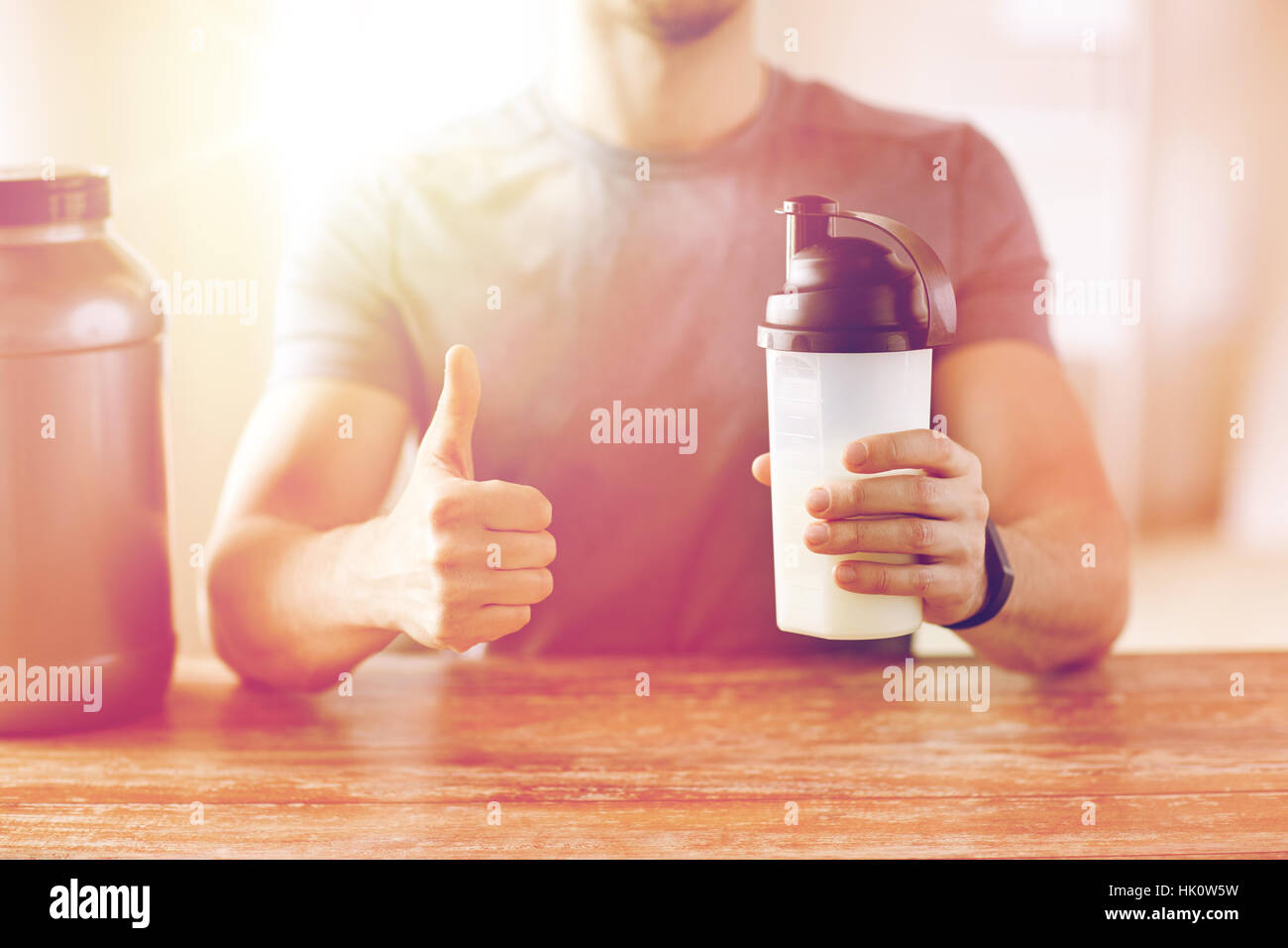 Mann mit Protein shake Flasche Daumen auftauchen Stockfoto