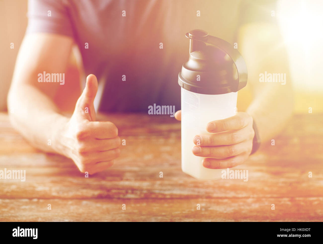 Mann mit Protein shake Flasche Daumen auftauchen Stockfoto