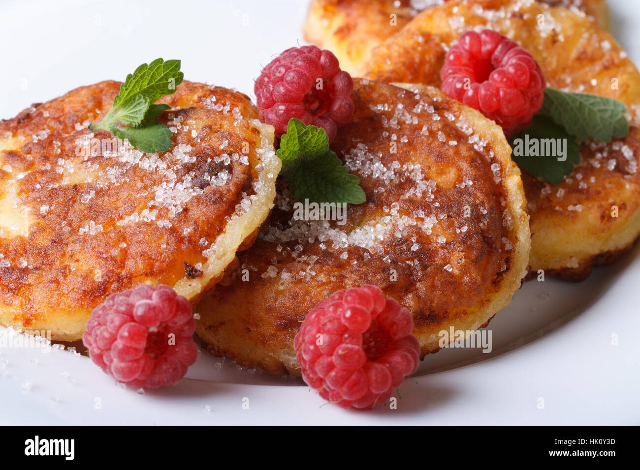 Leckere Käse-Pfannkuchen mit Himbeeren und Minze auf einem weißen Teller Closeup. horizontale Stockfoto