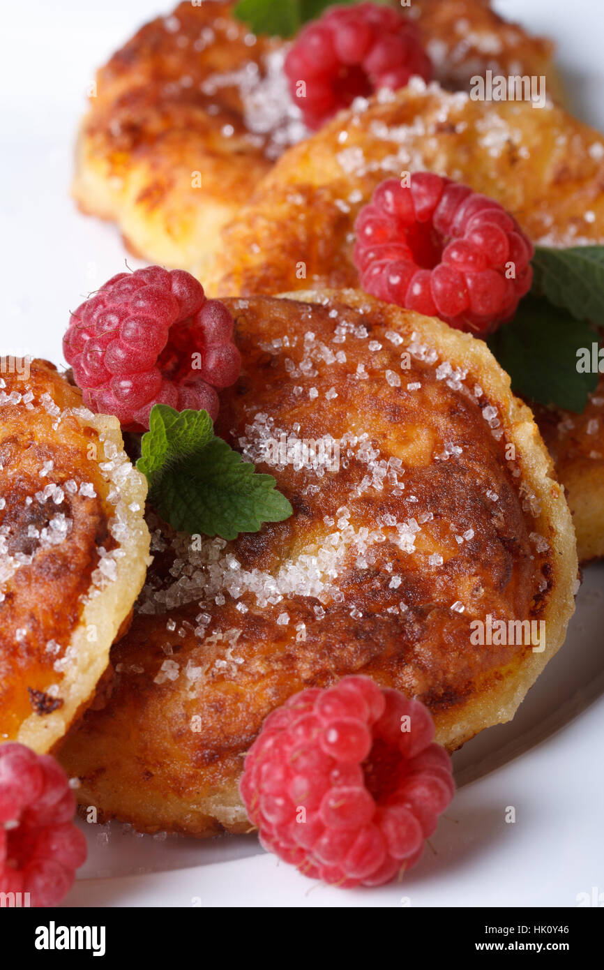 Leckere Käse-Pfannkuchen mit Himbeeren und Minze auf einem weißen Teller Closeup. vertikale Stockfoto