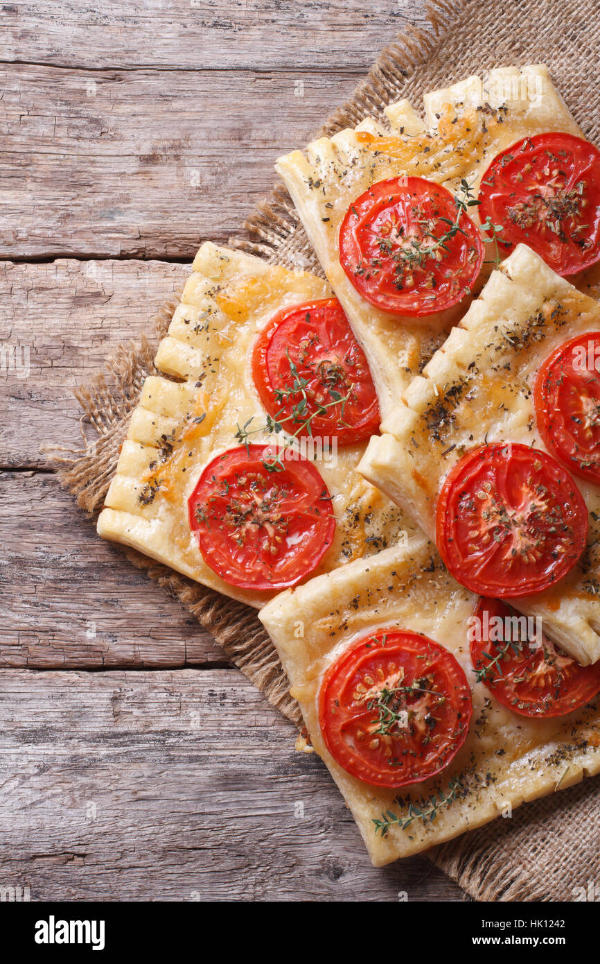 Blätterteig-Torte mit Tomaten und Käse auf dem Tisch close-up vertikalen. Ansicht von oben Stockfoto