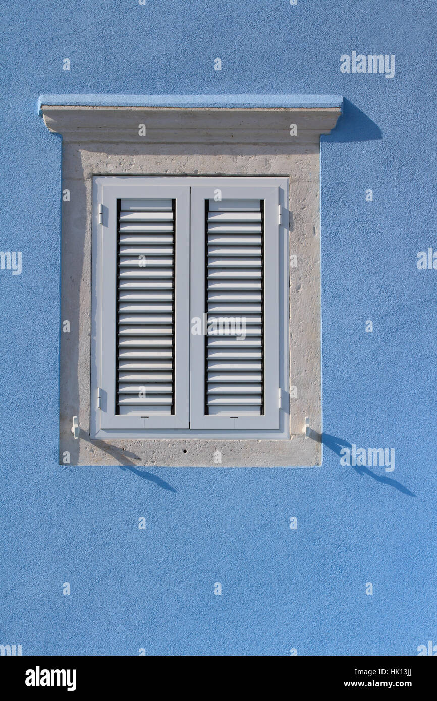 Geschlossene Fenster mit weißen vertikalen hölzerne Fensterläden schließen. Mediterranean Stockfoto