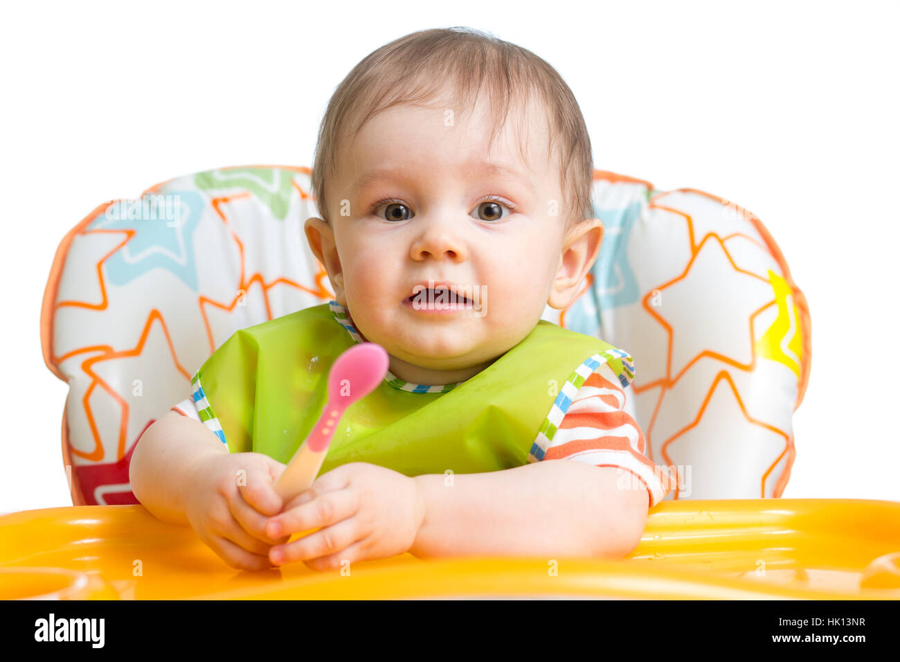 Kleines Baby isst. Kid Boy mit Löffel am Tisch sitzen. Stockfoto
