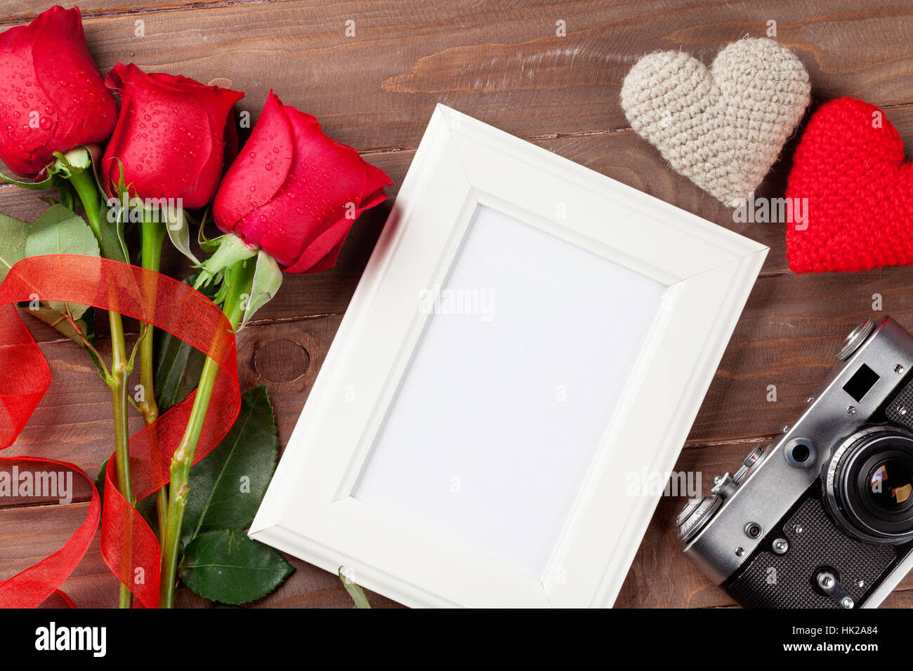 Valentinstag Rosen, Fotorahmen, Retro-Kamera und Herzen über hölzerne Hintergrund Stockfoto