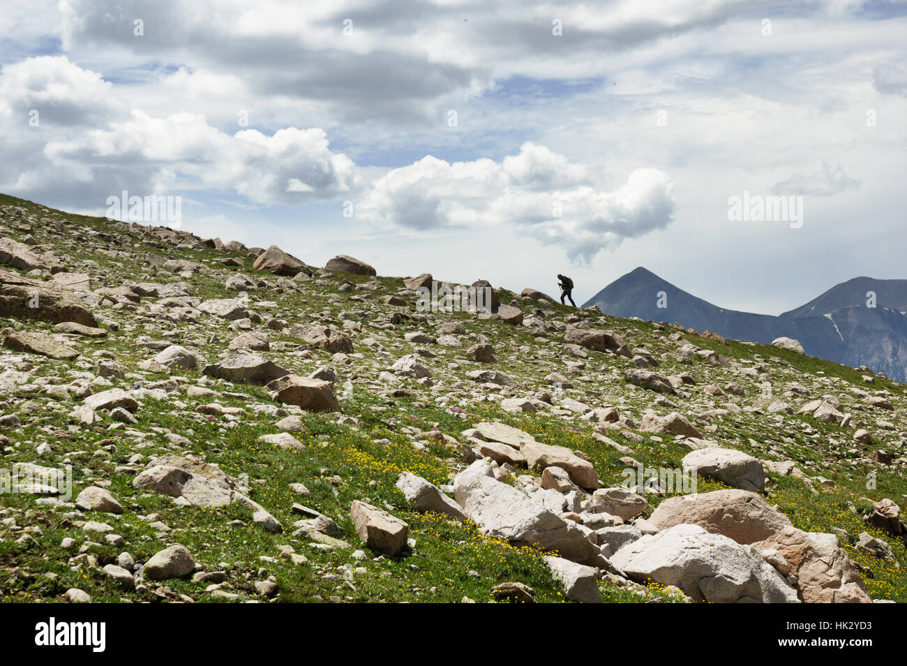 entfernte Frau Wandern auf einem Bergkamm in den San Juan Mountains von Colorado Stockfoto