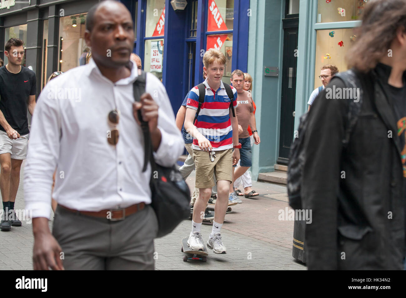 LONDON, ENGLAND - 12. Juli 2016 der junge im gestreiften T-shirt durch die Menge in der Carnaby Street Skaten Stockfoto