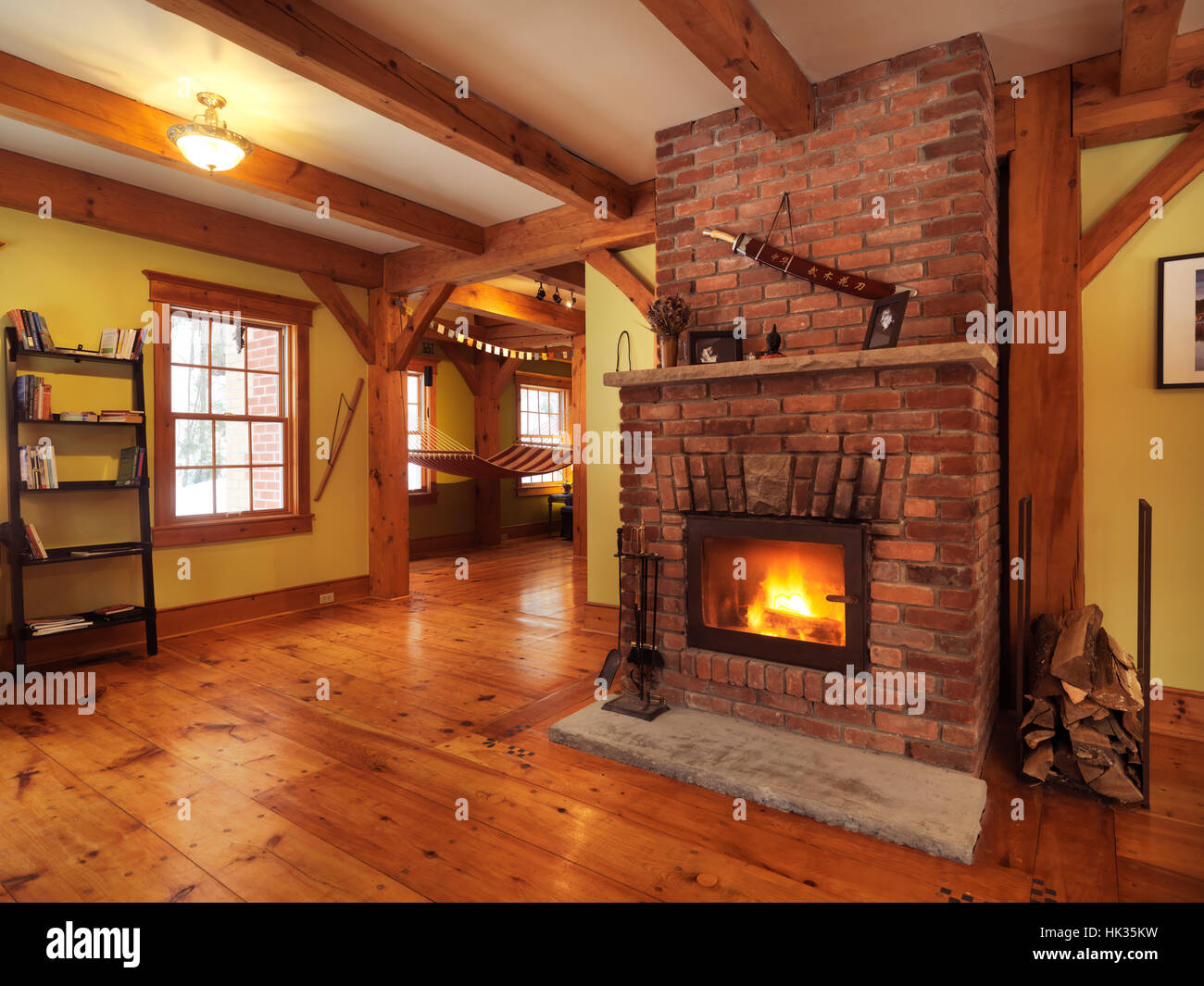 Brennender Kamin in einem Timberframe kanadische Land Haus Wohnzimmer Interieur, Muskoka, Ontario, Kanada Stockfoto