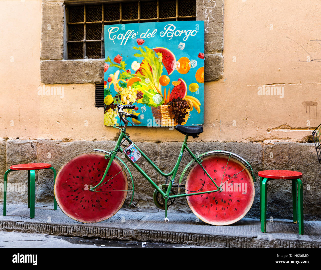 Altes grünes Fahrrad mit Rädern gemacht auszusehen wie ein Stück Wassermelone, Florenz, Italien. Stockfoto