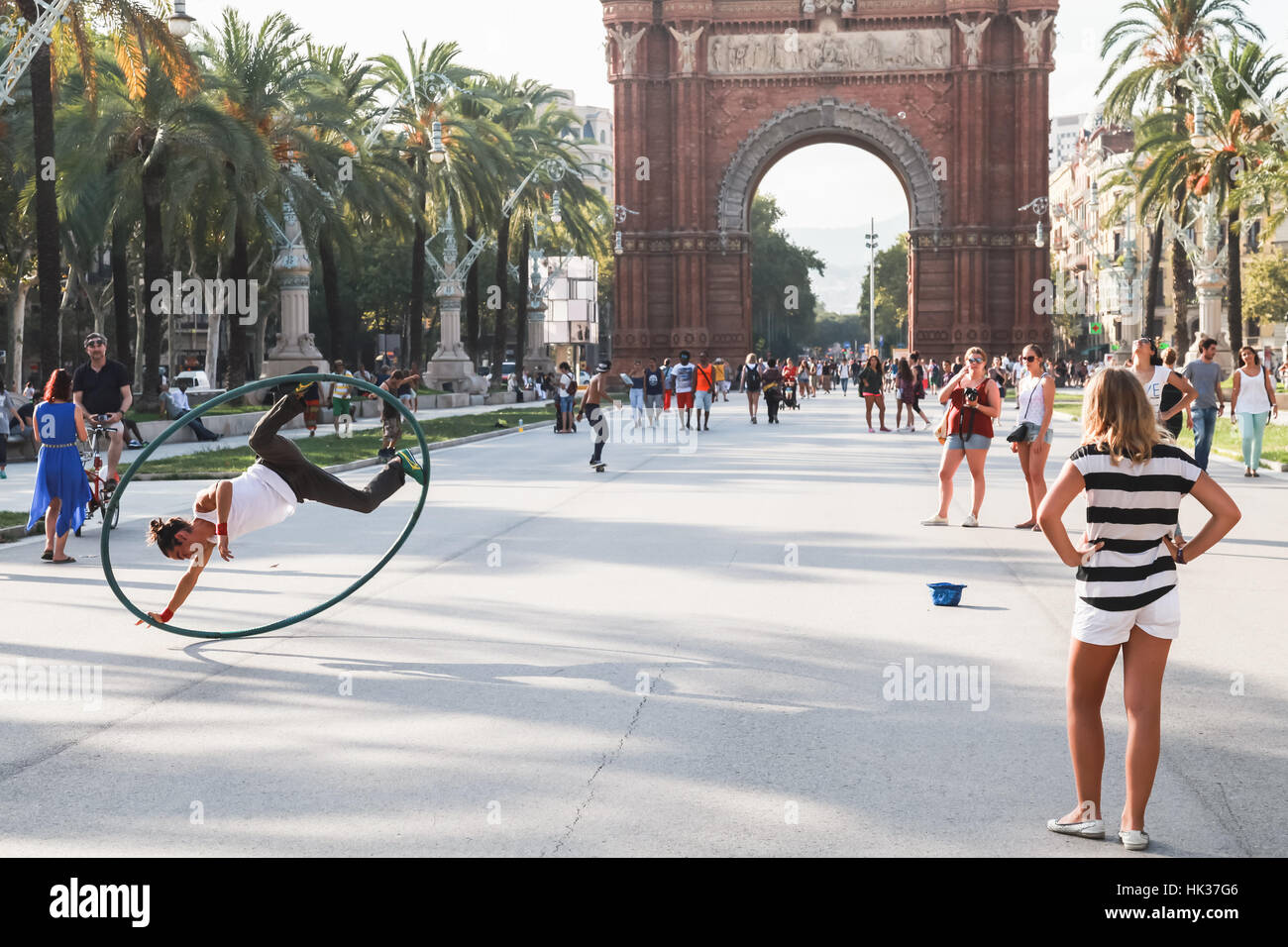 Barcelona, Spanien - 26. August 2014: Acrobat mit Hoop macht Leistung in Ciutadella Park, Triumphbogen auf einem Hintergrund Stockfoto