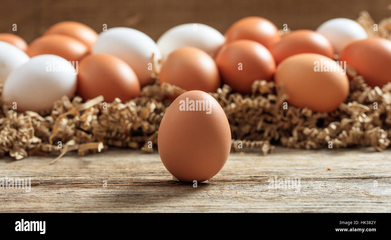 Braunen und weißen Eiern auf einer Holzoberfläche Stockfoto