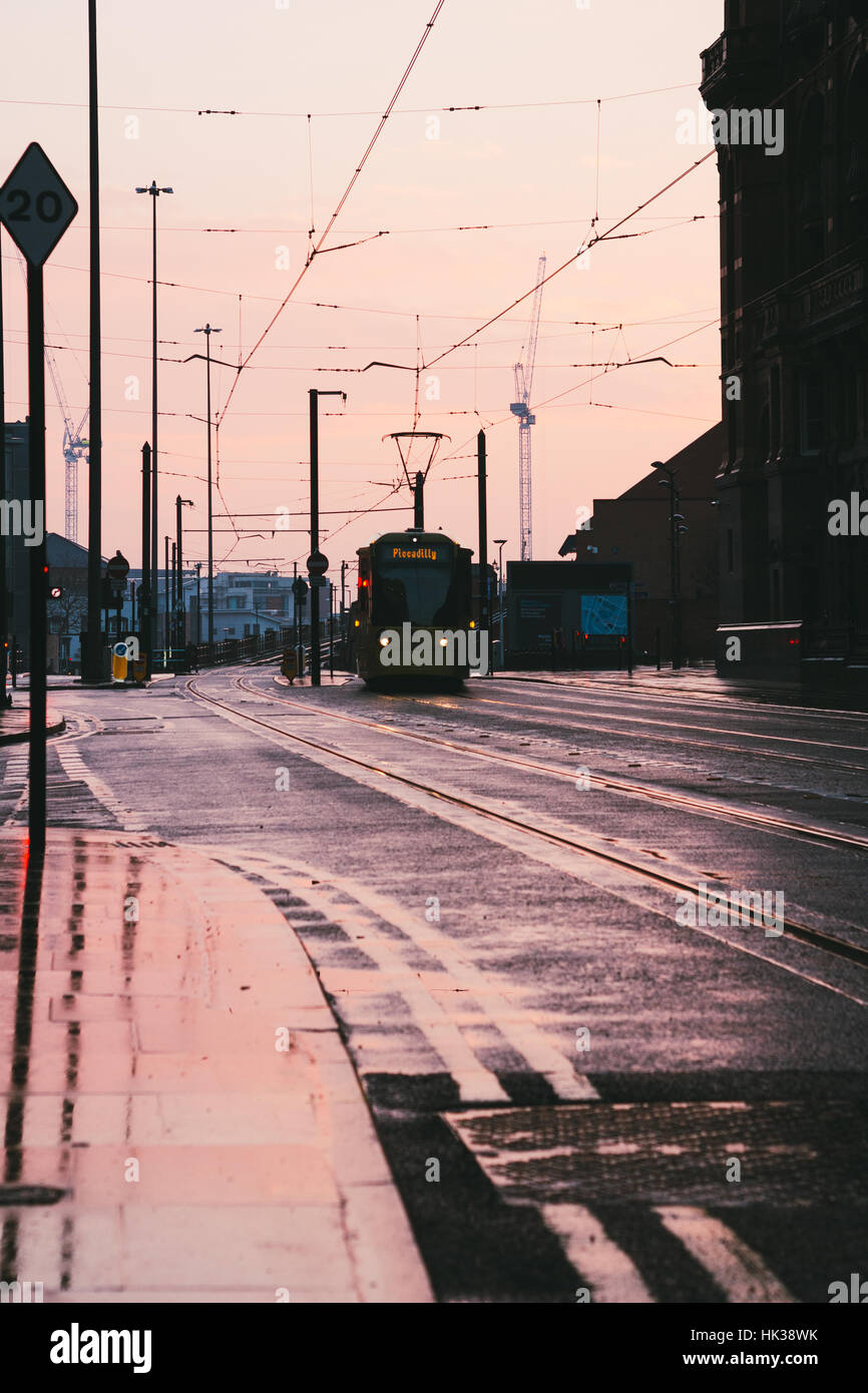 Sonnenuntergang in Manchester mit einer Straßenbahn in der Ferne Stockfoto