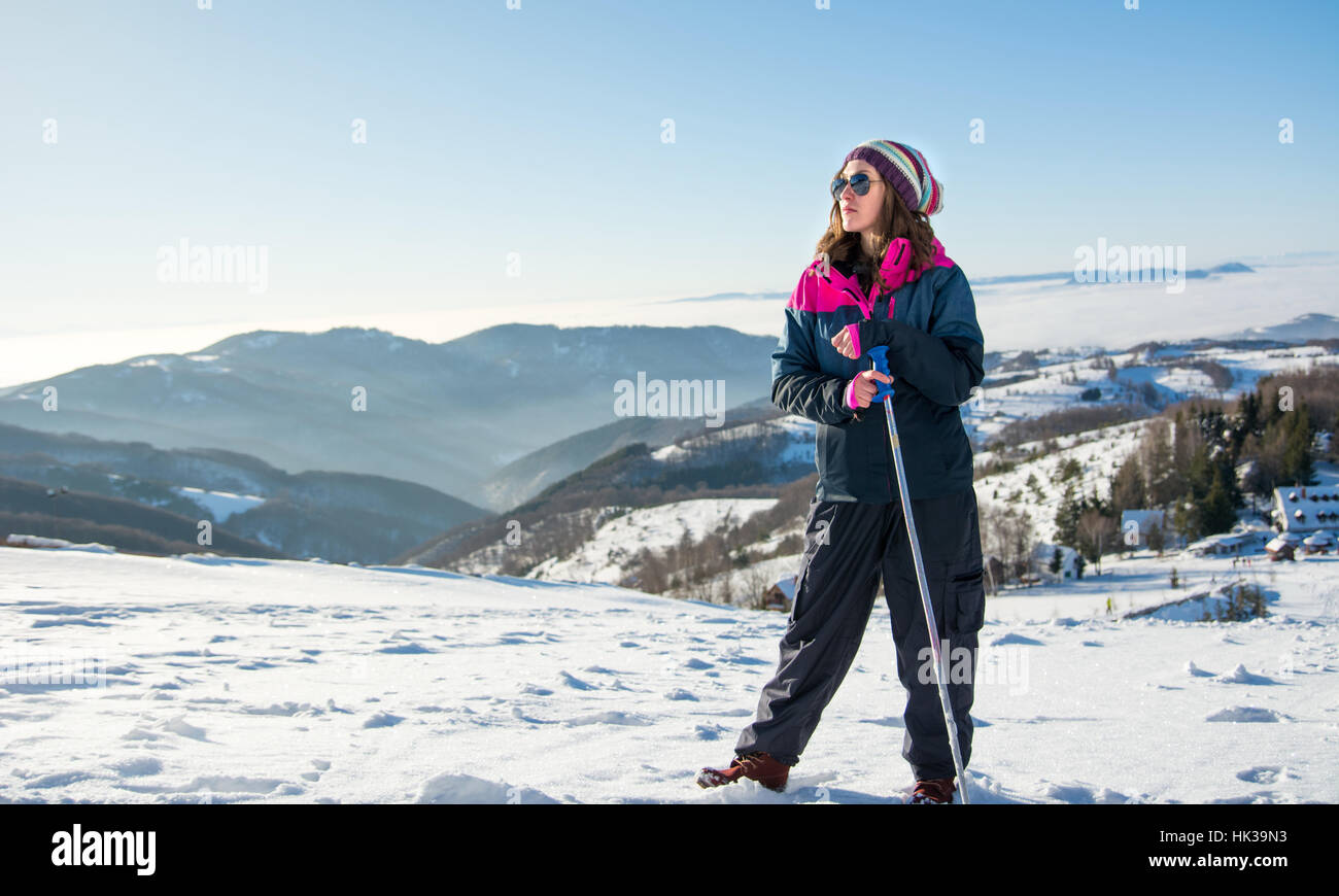 Wanderer mit Stöcken auf den verschneiten Berg stehend Stockfoto