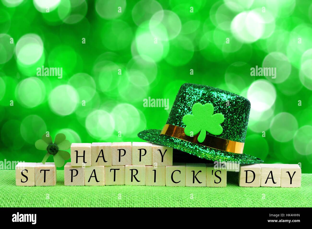 Glücklich St. Patricks Tag Holzblöcke mit Kobold Hut und Shamrock über funkelnden grünen Hintergrund Stockfoto