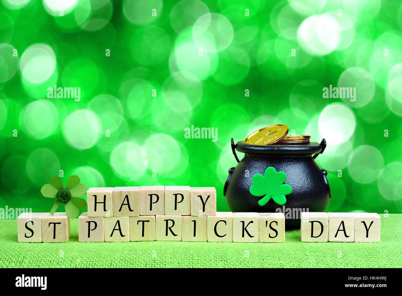 Glücklich St. Patricks Tag Holzblöcke mit Pot of Gold und Shamrock über funkelnden grünen Hintergrund Stockfoto