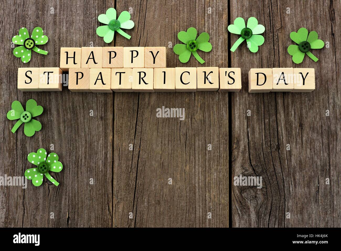 Glücklich St. Patricks Tag Holzblöcke mit handgeschöpftem Papier Kleeblätter über einen rustikalen hölzernen Hintergrund Stockfoto