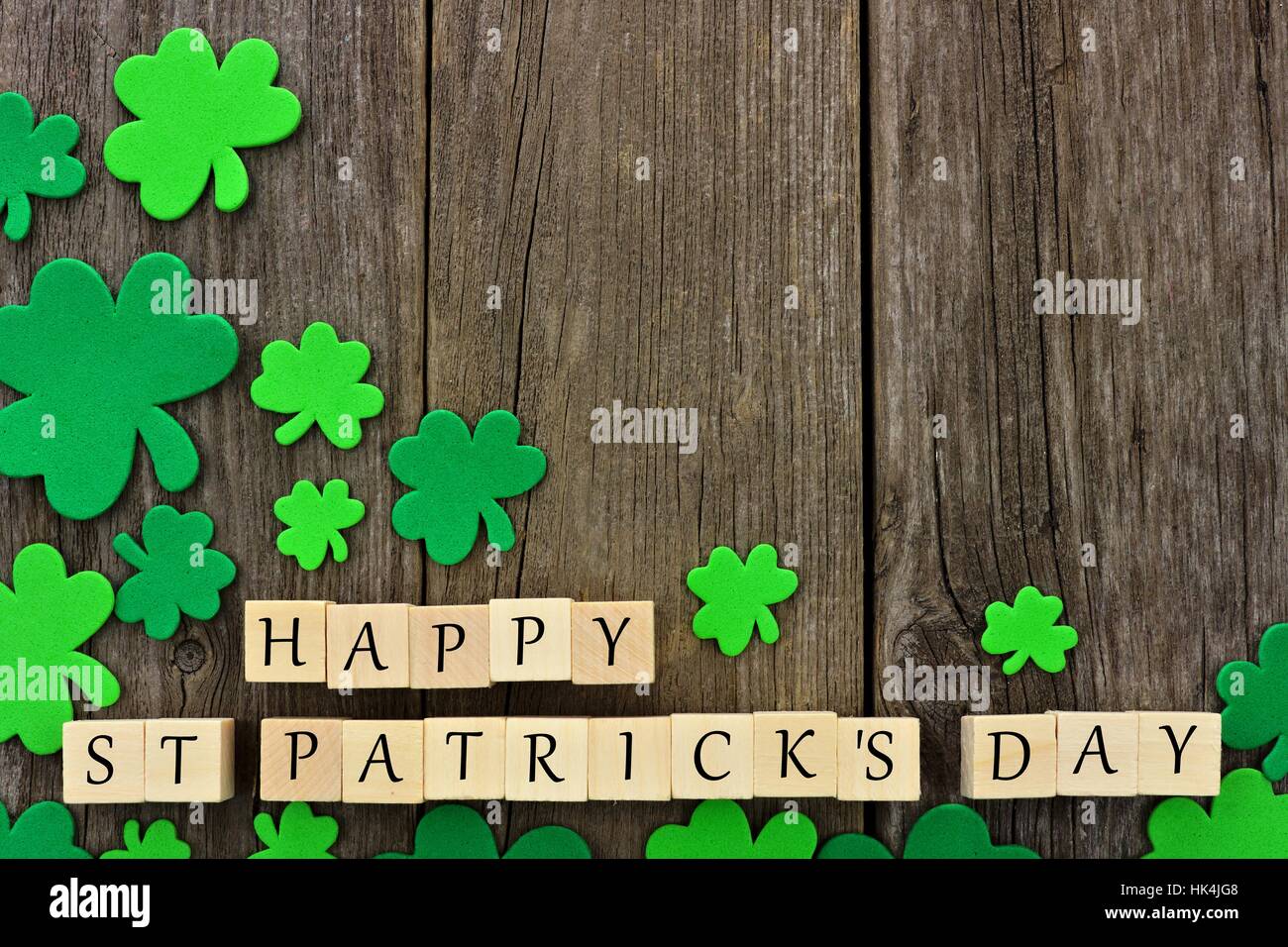 Glücklich St. Patricks Tag Holzblöcke mit Ecke Grenze der Kleeblätter über einen rustikalen hölzernen Hintergrund Stockfoto