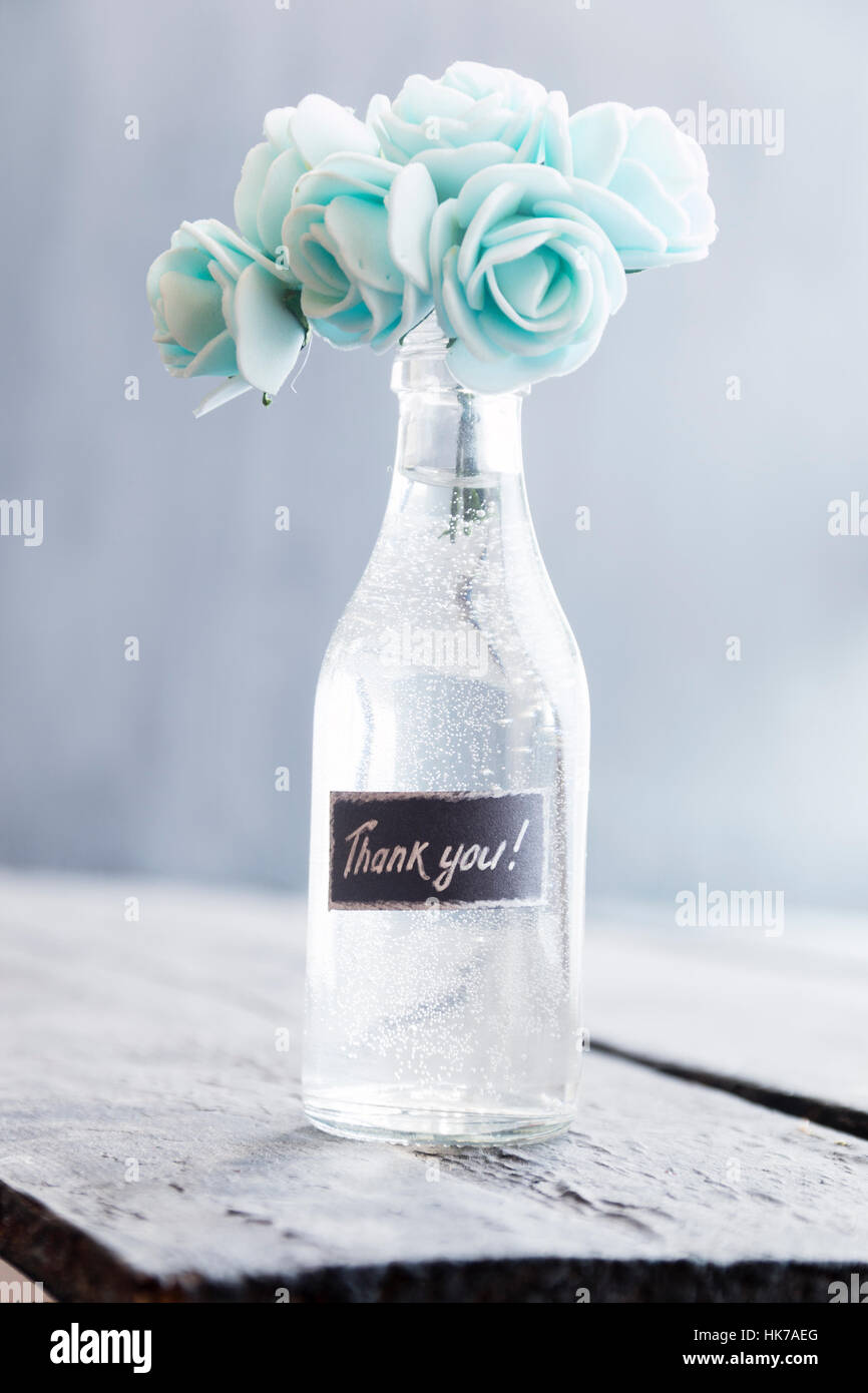 Danke-Schriftzug und Flasche mit Blumen Stockfoto