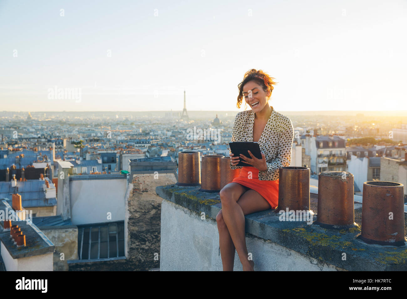 Junge Frau mit einem TabletPC auf den Dächern von Paris Stockfoto