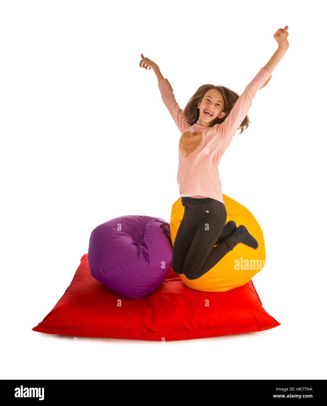 Glückliches Mädchen springen in der Nähe von Sitzsäcke und Sitzsack Sofa isoliert auf weißem Hintergrund Stockfoto