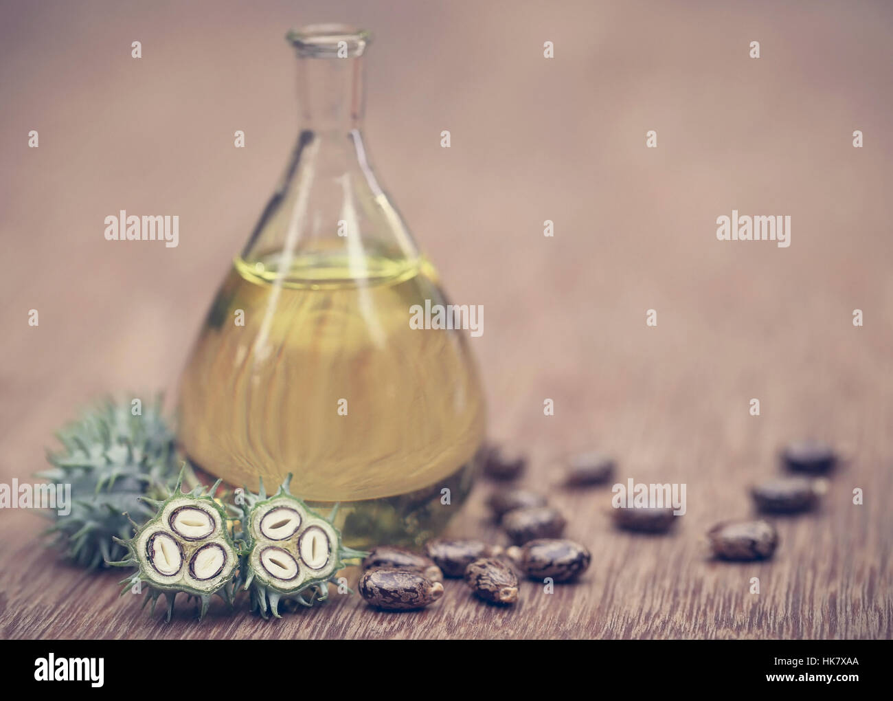 Rizinusöl mit trockenen und grünen Bohnen auf Holzuntergrund Stockfoto