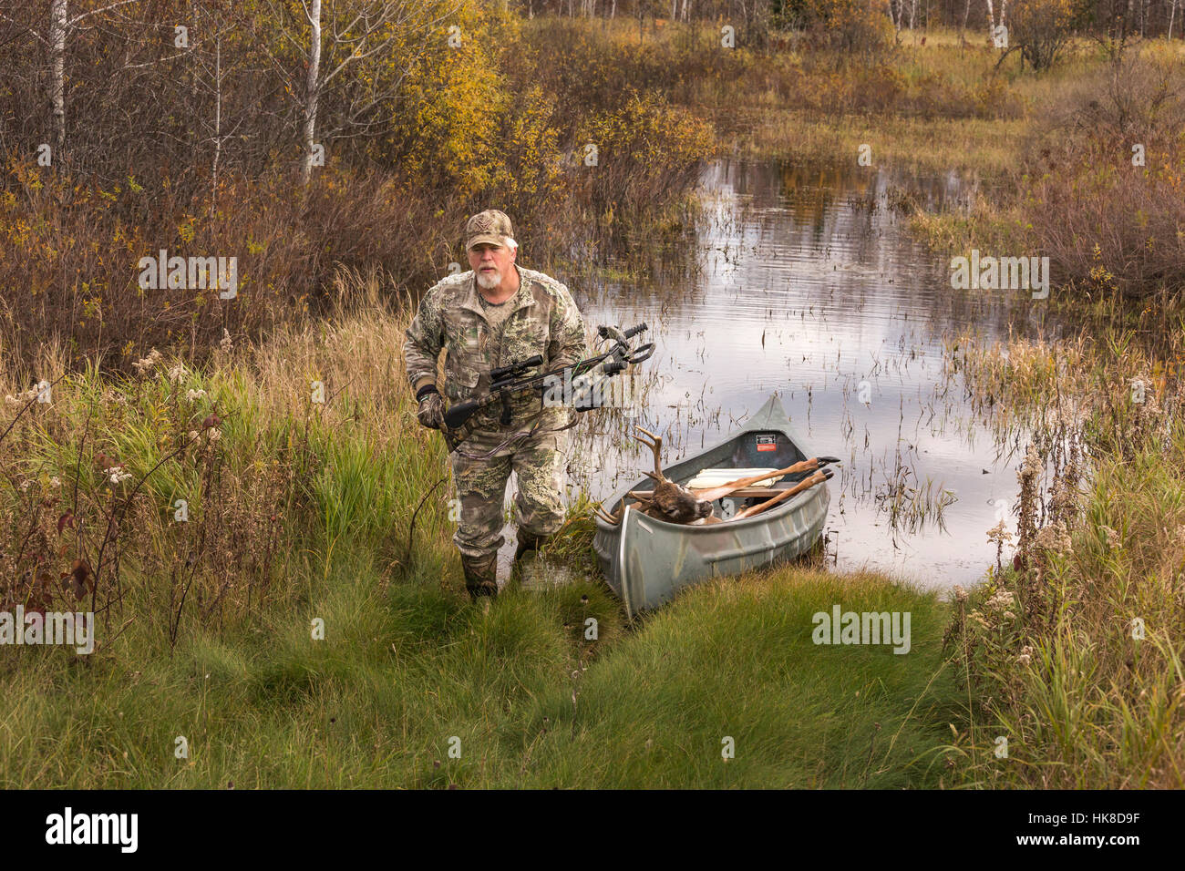 Erfolgreiche Bogenjäger zurück, mit dem Kanu, mit seinem 8-Punkt-Buck. Stockfoto