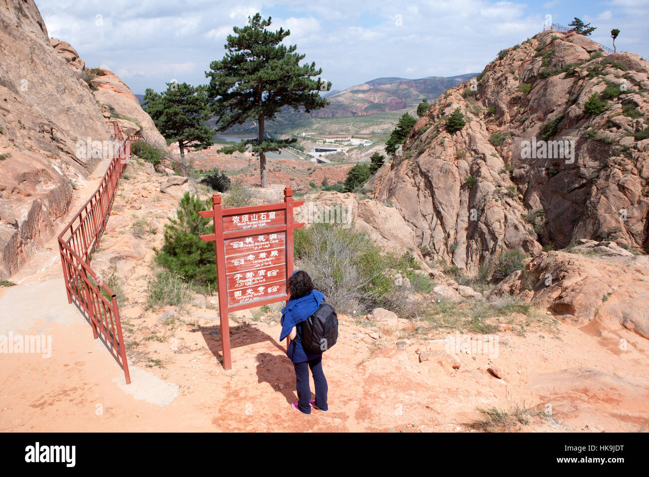 Ein Tourist schaut Xumi Shan Grotten der Vorstand mit den Richtungen der Pfade. Sanying, Guyuan, Ningxia, China Stockfoto