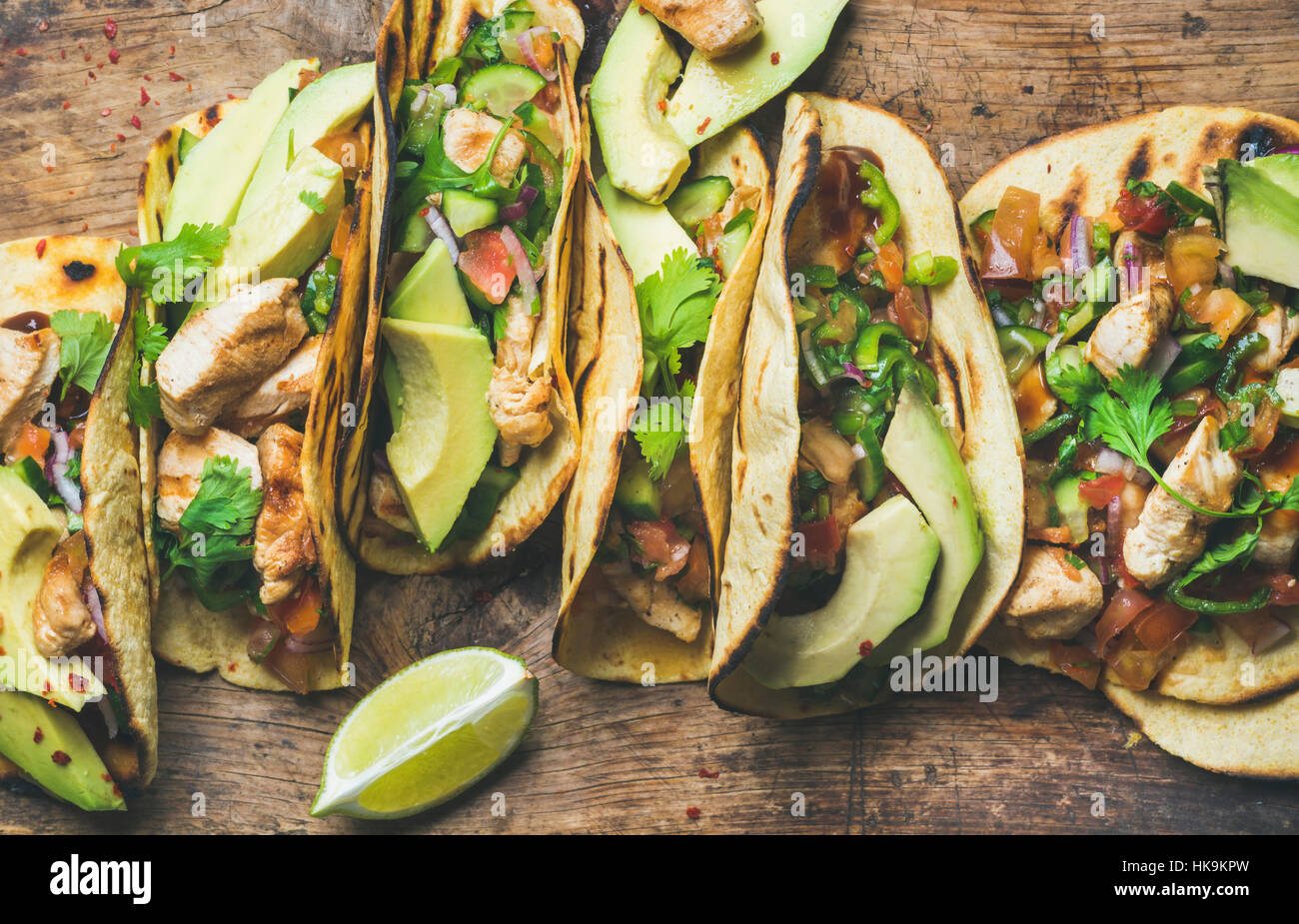 Tacos mit gegrilltem Hähnchen, Avocado, frische Salsa Sauce und Limetten über rustikalen hölzernen Hintergrund, Ansicht von oben. Gesunden low Carb und low Fett Mittagessen oder Lebensmittel f Stockfoto