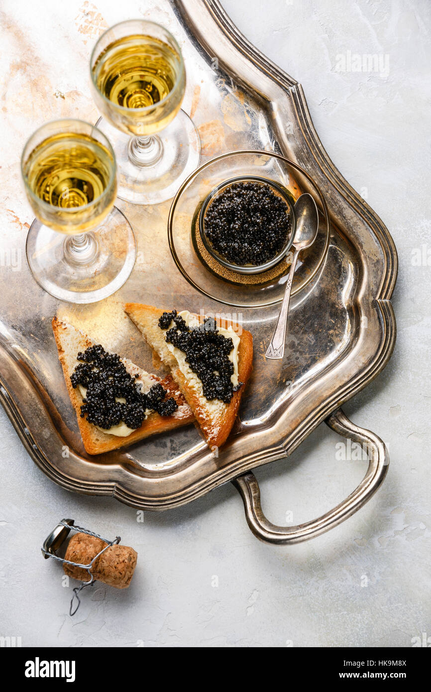 Störkaviar schwarz, Sandwiches und Champagner auf silbernen Tablett Stockfoto