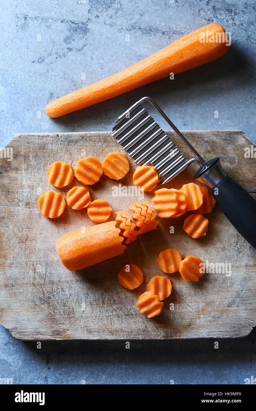 Crinkle schneiden in Scheiben geschnittenen Karotten auf einem Holzbrett. Ansicht von oben Stockfoto