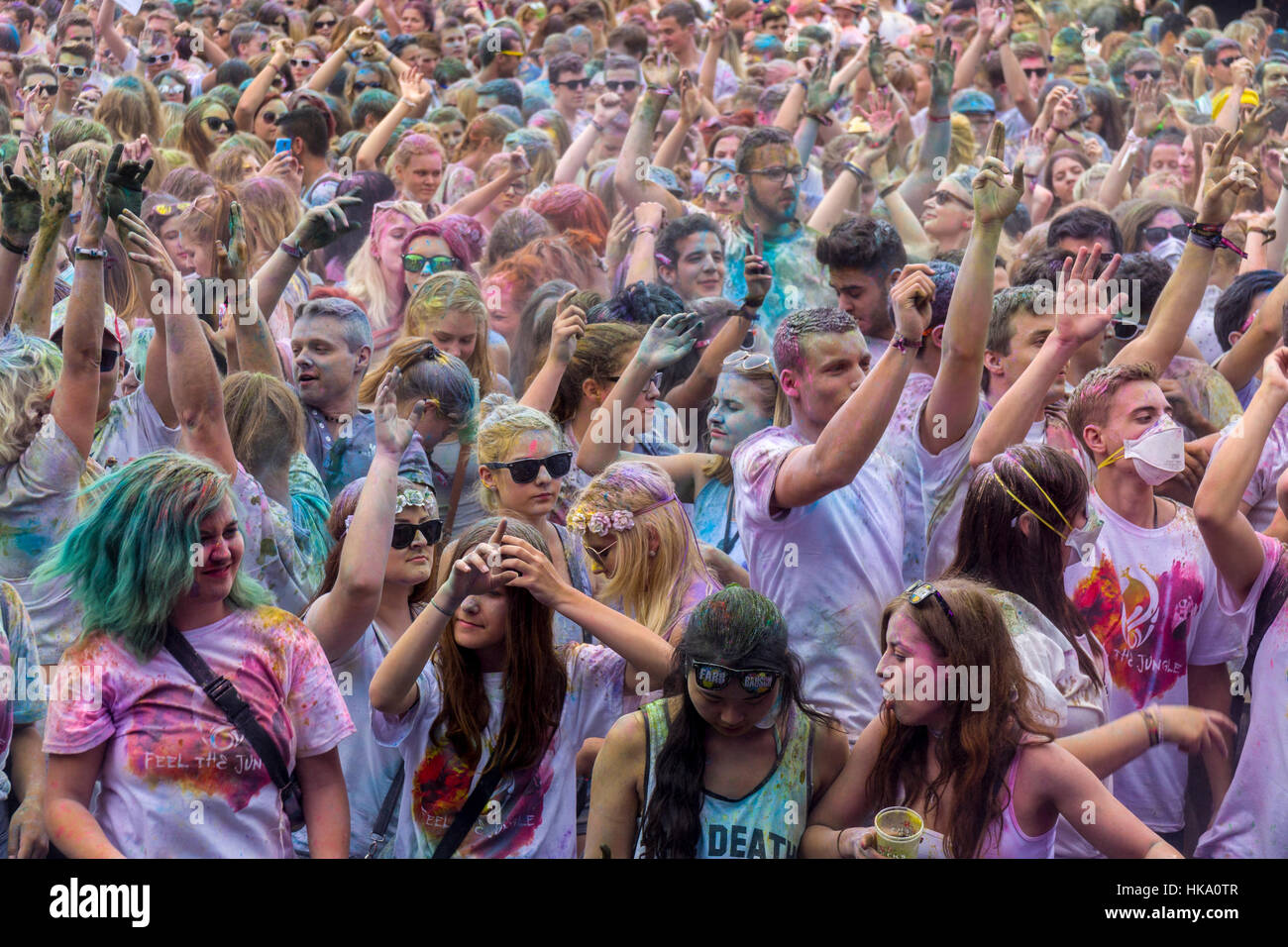 Tausende von jungen Frauen und Mann heben ihre Arme auf dem bunten Holi-festival Stockfoto