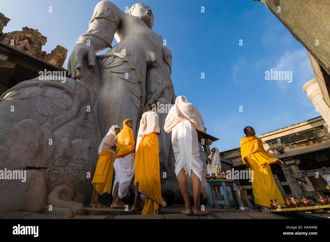 Eine Gruppe von Jain Pilgern ist religiöse Texte zu Füßen des Gomateshwara, die Statue von Bahubali auf Indragiri Hügel in Sravanabelagola rezitieren. Stockfoto