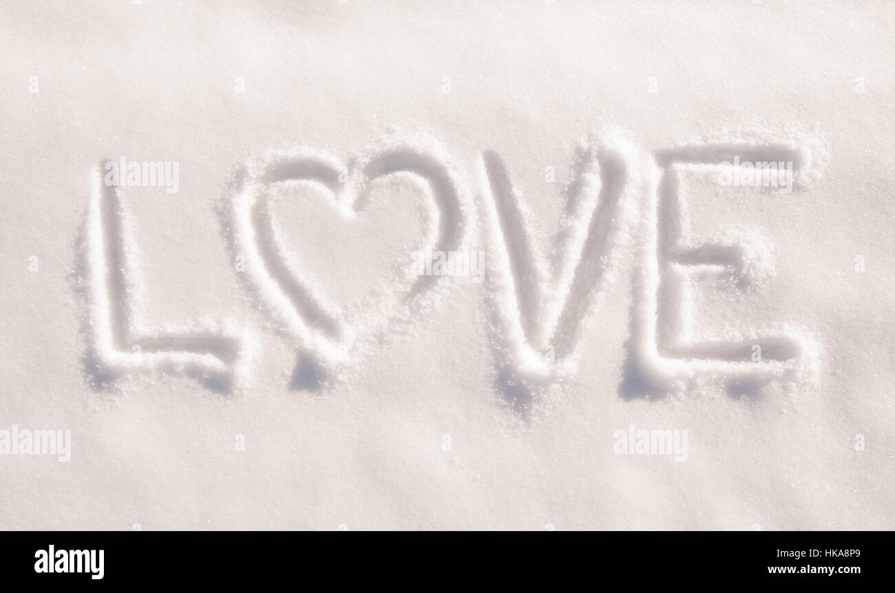 Wort Liebe mit einem Herzen, geschrieben im frischen Pulverschnee - Konzept des Liebens Winterwetter Stockfoto