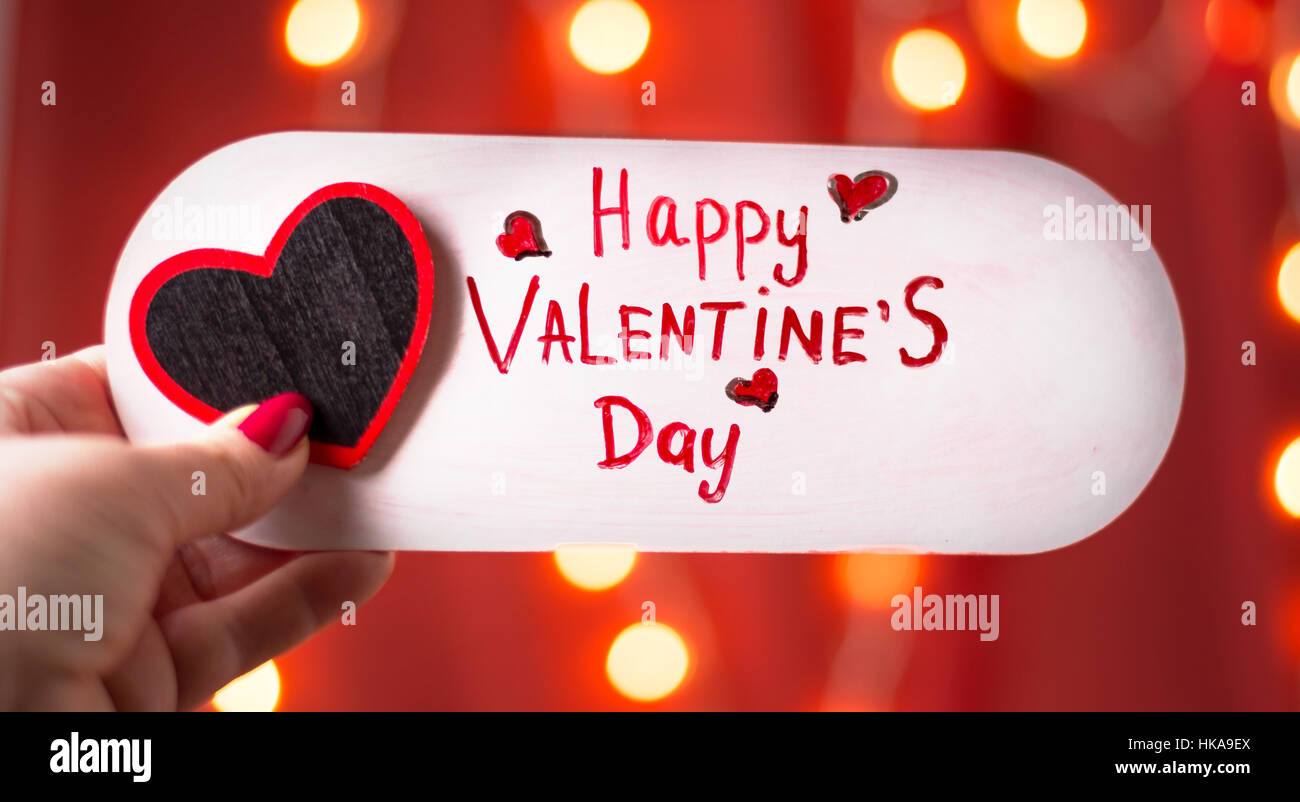 Weibliche Hand mit Happy Valentines Day Karte Stockfoto
