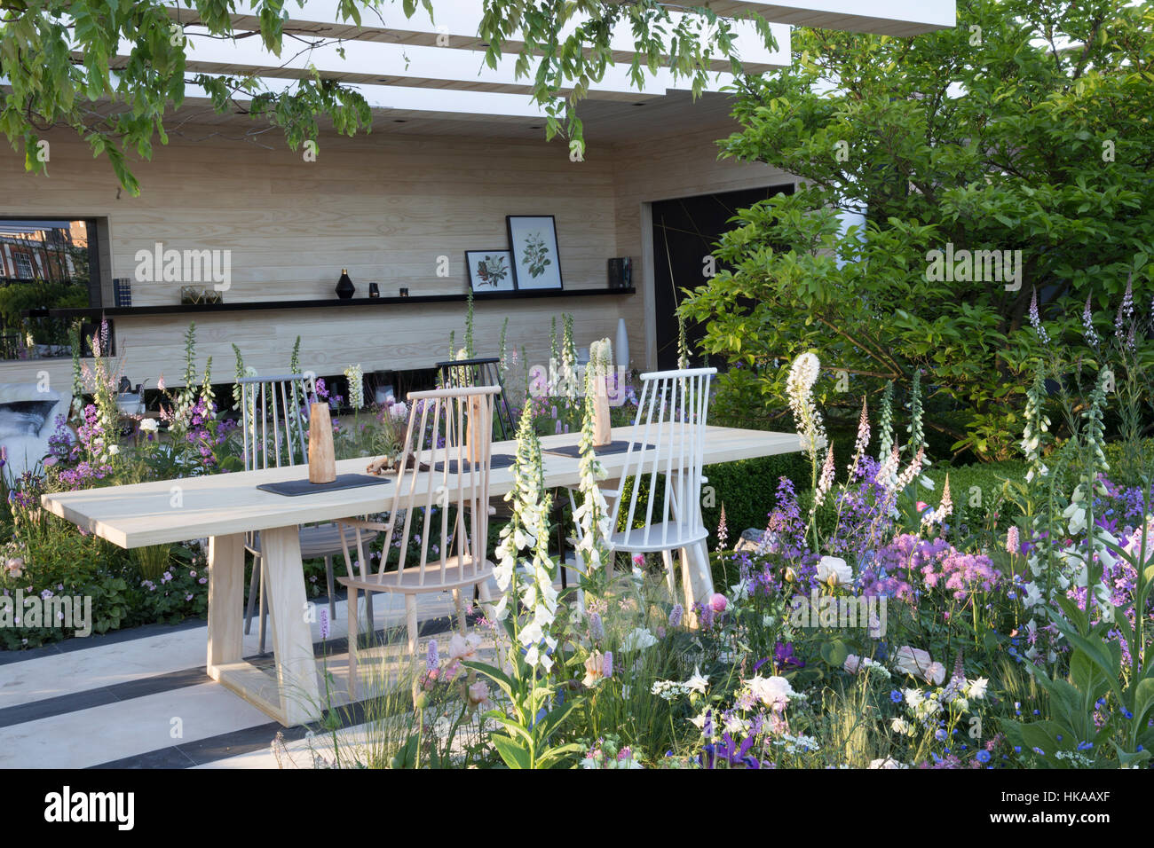 Garten Essbereich im Freien Terrasse Gartenmöbel mit Tisch und Stühlen, Blumenrand rechts Chelsea Flower Show UK Stockfoto