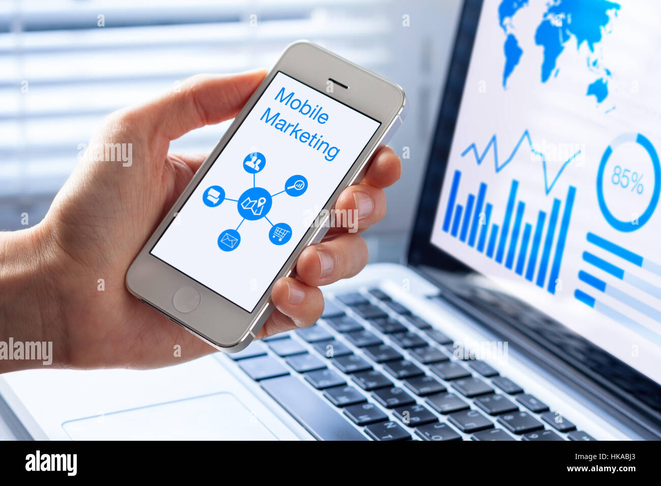 Mobile Marketing und Customer Analytics Datenkonzept mit einer Person, die einen Smartphonebildschirm und einem computer Stockfoto