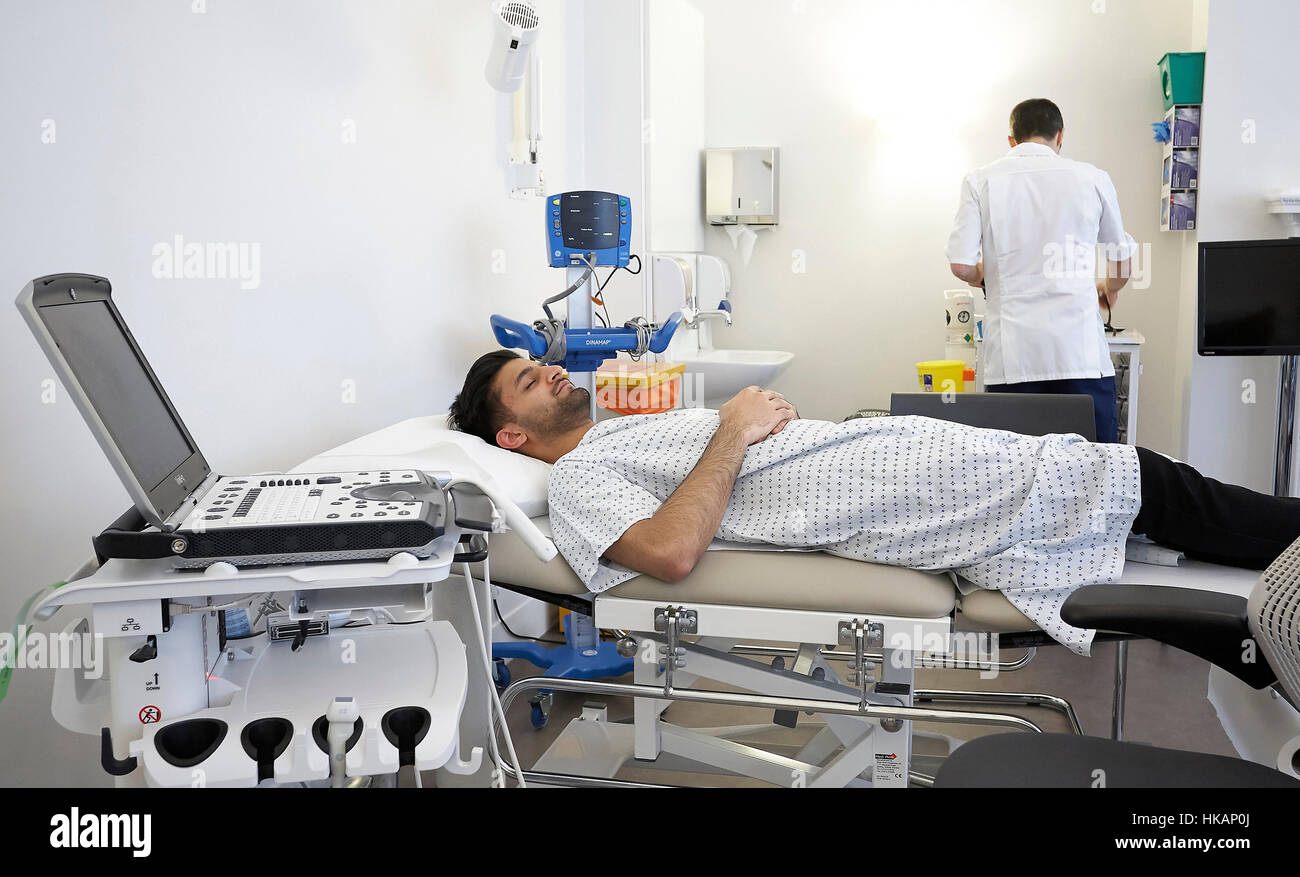 Für einige Tests bereitet Patienten liegen in einem Krankenhausbett während eines Arztes. Stockfoto