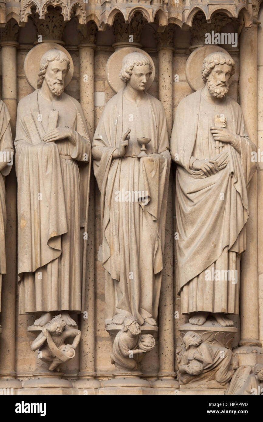 Apostel St. Andrew, St. Johannes der Evangelist und St. Peter (von links nach rechts). Neo-gotischen Statuen an der Hauptfassade der Kathedrale Notre-Dame (Notre-Dame de Paris) in Paris, Frankreich. Beschädigte gotische Statuen an der Hauptfassade wurden in den 1840er Jahren von französischen Architekten Eugene Viollet-le-Duc und Jean-Baptiste Lassus restauriert. Stockfoto