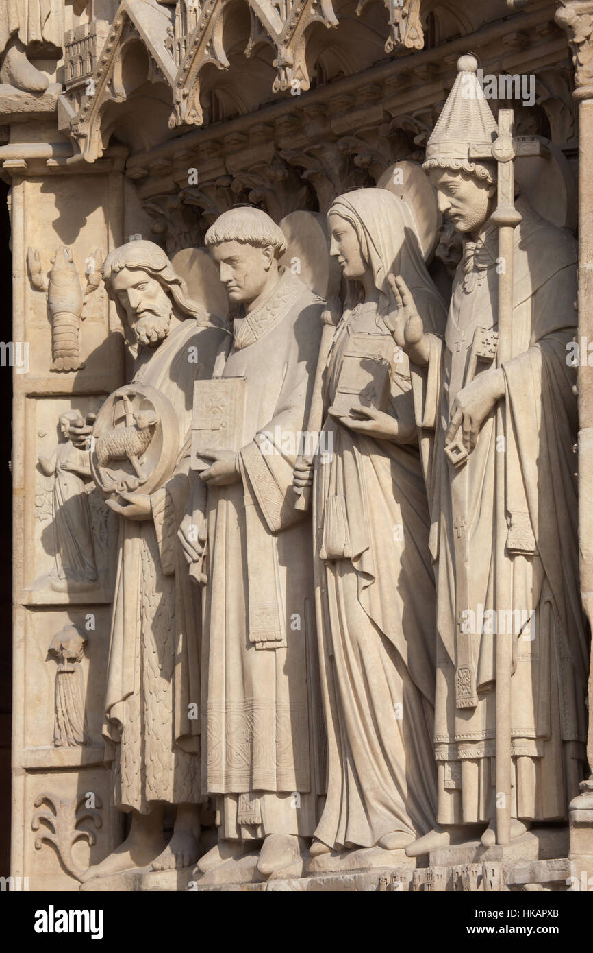 St. Johannes der Täufer, St. Stephan, St. Genevieve und Papst St. Sylvester I (von links nach rechts). Neo-gotischen Statuen an der Hauptfassade der Kathedrale Notre-Dame (Notre-Dame de Paris) in Paris, Frankreich. Beschädigte gotische Statuen an der Hauptfassade wurden in den 1840er Jahren von französischen Architekten Eugene Viollet-le-Duc und Jean-Baptiste Lassus restauriert. Stockfoto