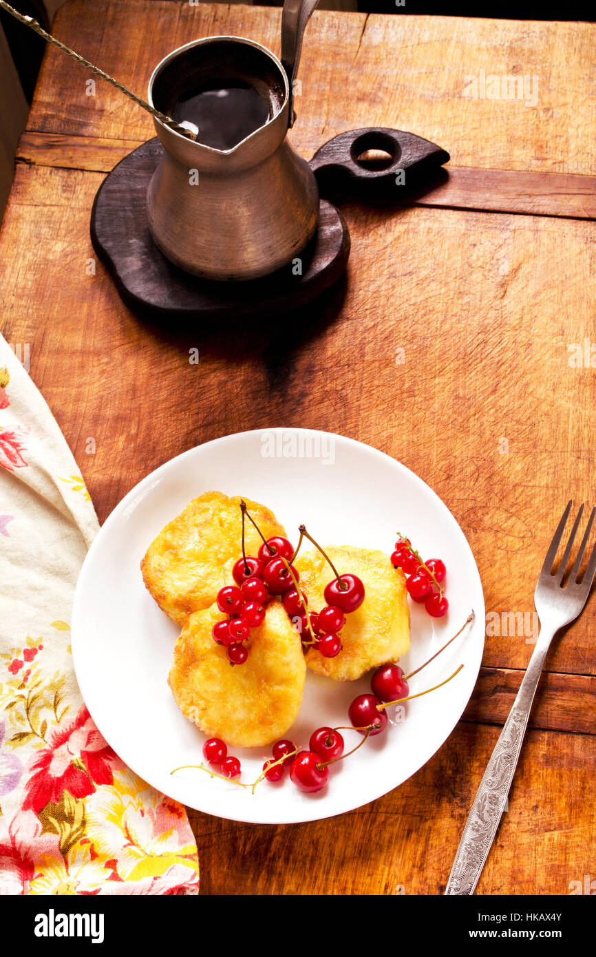 Käse-Pfannkuchen serviert in Platte und Kaffee Topf auf Tisch Stockfoto