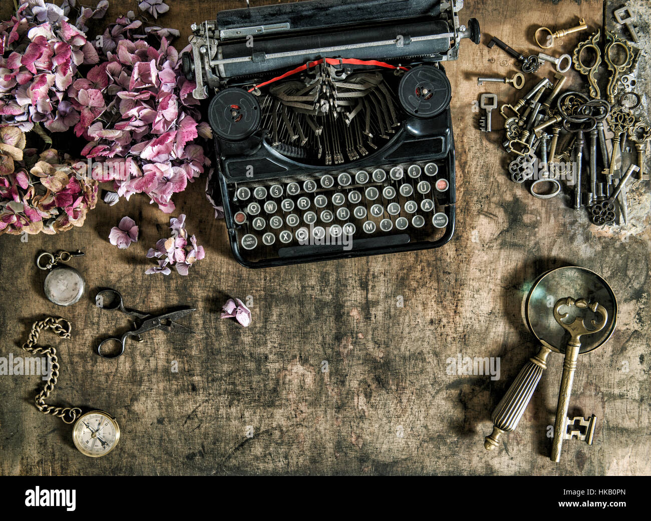 Vintage Schreibmaschine, Hortensia Blumen und alten Schlüssel auf Holztisch. Nostalgische Stillleben Stockfoto