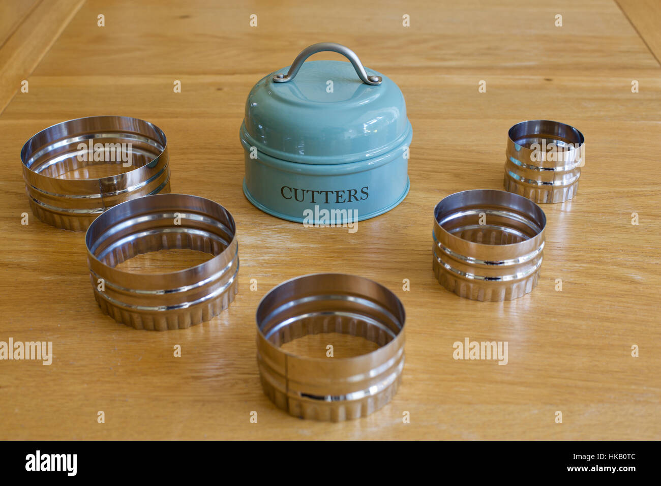 Satz von traditionellen 5 fünf Keks Ausstechformen angelegt auf einem Holztisch in der Küche mit Metallhalter Stockfoto